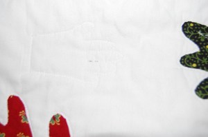 I quilted a baby hand into the background. I also added "Honk, Honk", "Meow, Meow", "Woof, Woof", "Cluck, Cluck", and "Oink, Oink" above the related animal shapes.