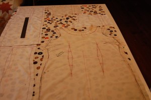 The fabric is shown 35" flat on my cutting table.  The muslin pattern piece for the front of the dress is on the right, and the two shortened back pieces are lined up smack against each other on the left.  The yoke pieces then fit above the dress front.  I did not need facings, as I lined the entire dress in a light weight linen/cotton blend, and finished the neck and armholes all by hand.  