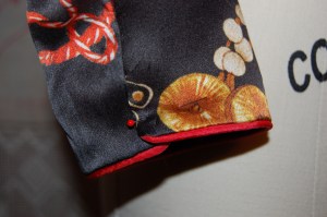 The sleeve has a side opening - to be secured by snaps.  Here it is just pinned.