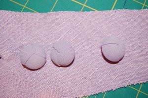 I think this photo shows the "monkey's knot" design in the buttons, which compliments the linen weave, I think.