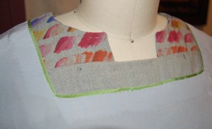 I used a gray Bemberg lining for this dress, but accented the neck edge with green piping. Obviously, no one sees this but me!