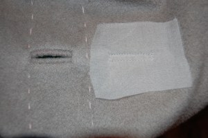 The line of basting stitches is the fold line - the organza patch is on the facing part of the front edge.