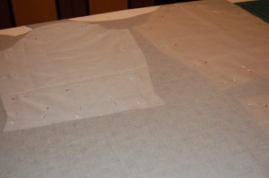 For those of you who asked, here is a picture of the silk organza being used as the pattern piece. when cut out, the two are basted together by hand along the seam lines, dart markings, and hem lines.